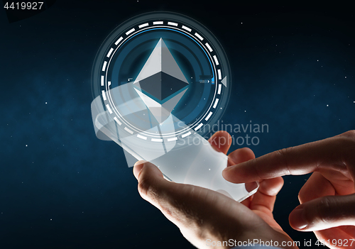 Image of businessman with smartphone and ethereum hologram