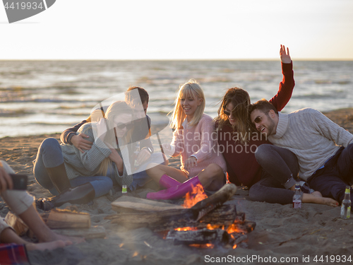 Image of Friends having fun at beach on autumn day