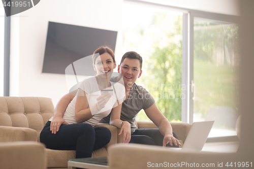 Image of happy young couple buying online