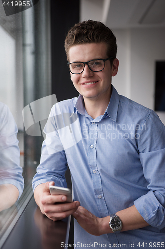 Image of Businessman Standing In A Modern Building Near The Window With P