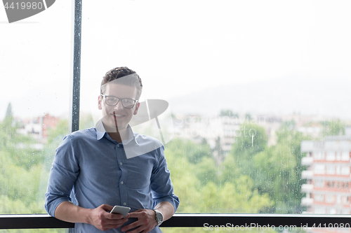 Image of Businessman Standing In A Modern Building Near The Window With P