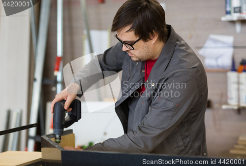 Image of assembler with screwdriver making furniture