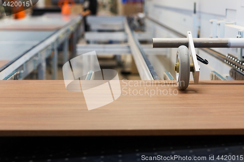 Image of wooden board on conveyer at furniture factory