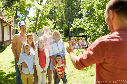 Image of happy family photographing by tablet pc in summer