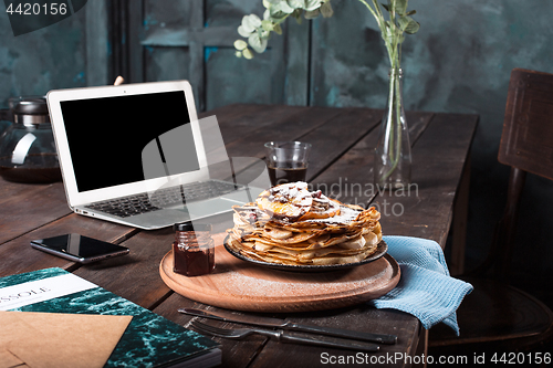 Image of Laptop and pancakes with juice. Healthy breakfast