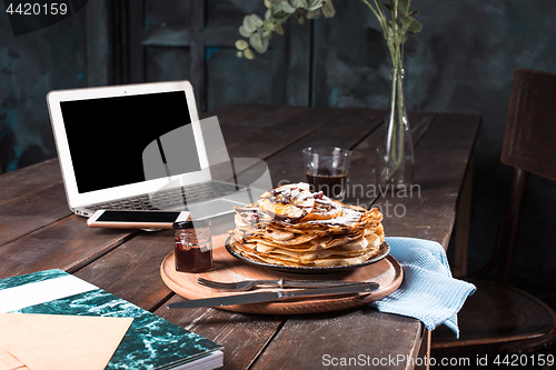 Image of Laptop and pancakes with juice. Healthy breakfast