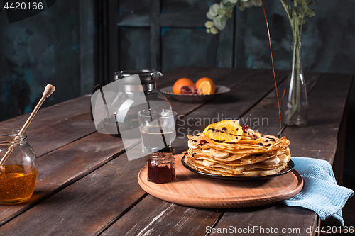 Image of Fresh homemade french crepes made with eggs, milk and flour, filled with marmalade on a vintage plate