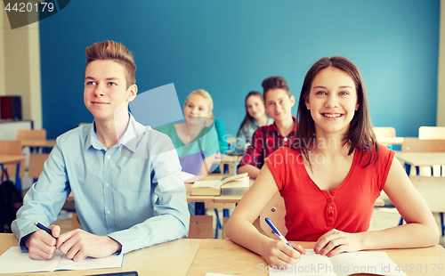 Image of happy students with notebooks at school