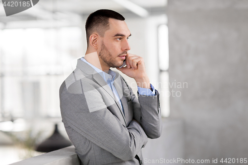 Image of businessman calling on smartphone at office