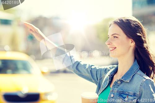 Image of happy young woman drinking coffee on city street