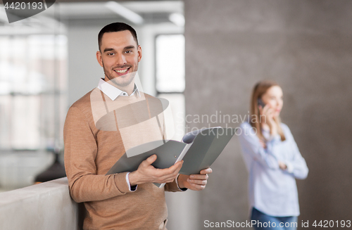 Image of smiling male office worker with folder