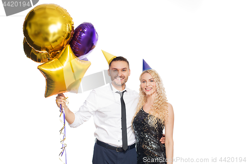 Image of happy couple with party caps and balloons