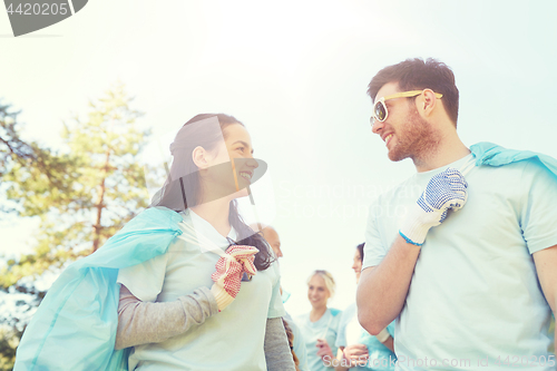 Image of volunteers with garbage bags talking outdoors