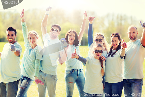 Image of group of volunteers showing thumbs up in park