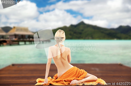 Image of woman with towel over exotic resort background