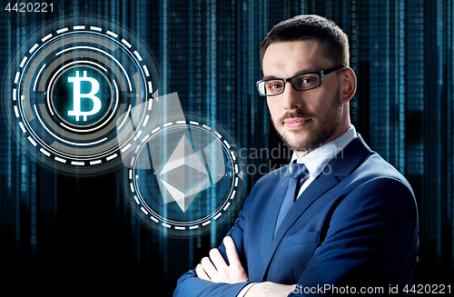 Image of businessman with cryptocurrency holograms