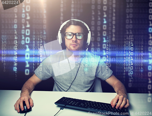 Image of man in headset hacking computer or programming