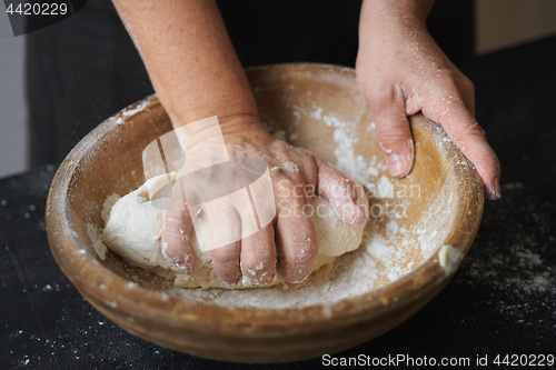 Image of Baker hands kneading dough