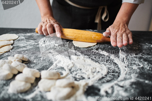 Image of Woman rolling the dough by hands