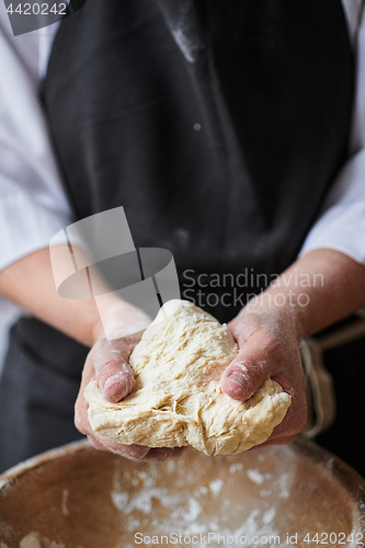 Image of Baker hands kneading dough