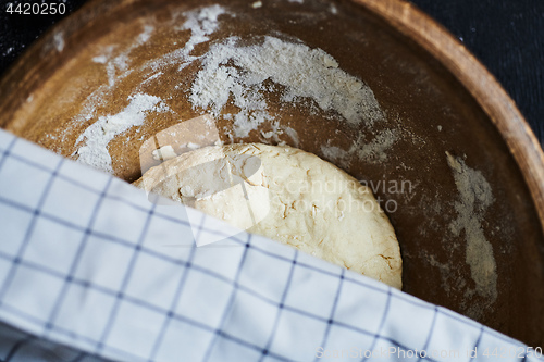 Image of Dough in a wooden bowl