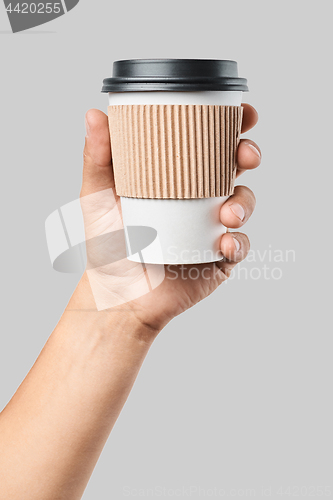 Image of Mockup of men\'s hand holding white paper mid size cup with black cover