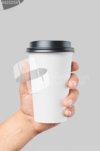 Image of Mockup of men\'s hand holding white paper large size cup with black cover