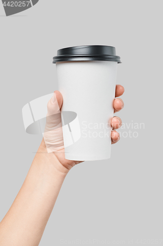 Image of Mockup of women\'s hand holding white paper large size cup with black cover