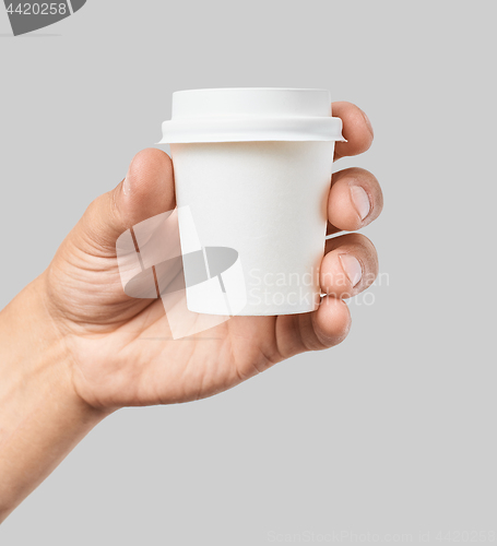 Image of Mockup of men\'s hand holding white paper espresso cup with white cover