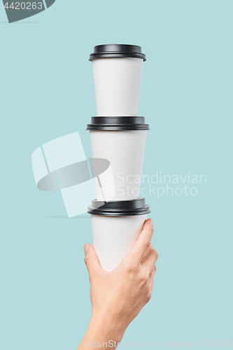 Image of Crop hand holding stack of paper cups