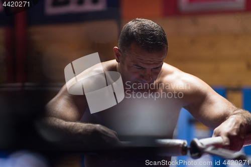 Image of kick boxer resting on the ropes in the corner