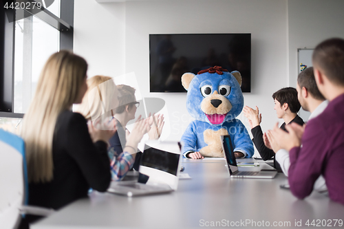 Image of boss dresed as bear having fun with business people in trendy of