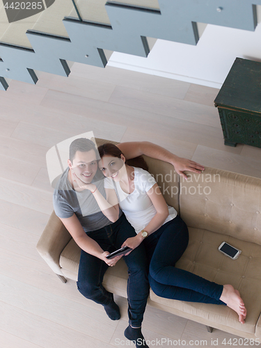 Image of couple relaxing at  home with tablet computers