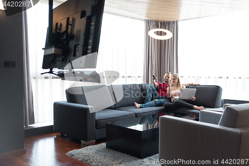 Image of happy couple relaxes in the living room