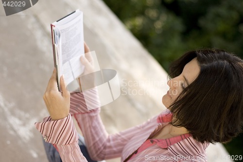 Image of female reading in park