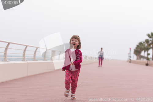 Image of mother and cute little girl on the promenade by the sea