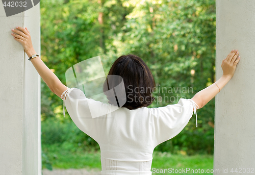 Image of woman in white dress looking out window