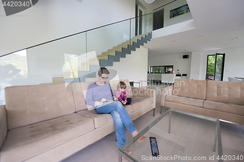 Image of mother and her cute little daughter are using a tablet