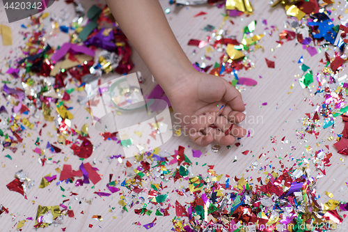 Image of Children\'s hand with confetti in background