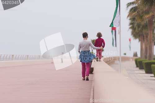 Image of mother and cute little girl on the promenade by the sea