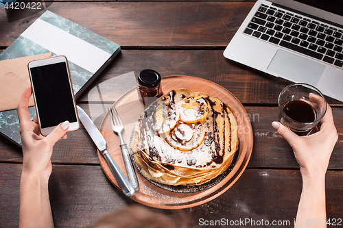 Image of Laptop and pancakes with juice. Healthy breakfast