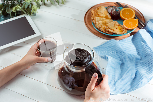 Image of The female hands and pancakes with juice. Healthy breakfast