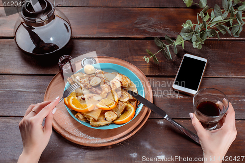 Image of The female hands and pancakes with juice. Healthy breakfast