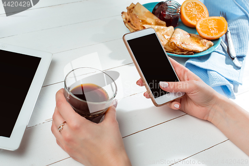 Image of The female hands and pancakes with juice. Healthy breakfast