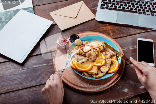 Image of Laptop and pancakes with juice. Healthy breakfast