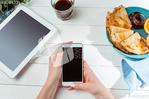 Image of The female hands and pancakes with juice. Healthy breakfast