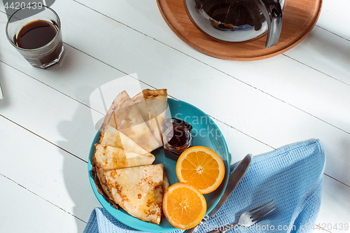 Image of Fresh homemade french crepes made with eggs, milk and flour, filled with marmalade on a vintage plate