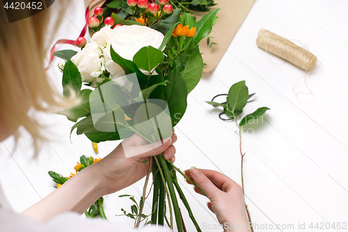 Image of Female florist making beautiful bouquet at flower shop