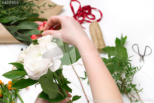 Image of Female florist making beautiful bouquet at flower shop