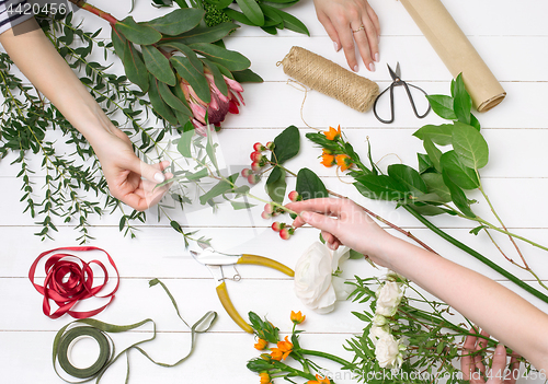 Image of Female florist making beautiful bouquet at flower shop